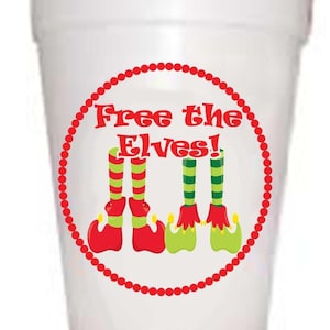 May include: White foam cup with a red circle and white polka dots around the edge. Inside the circle is the text "Free the Elves!" with an illustration of three elf legs wearing red and green striped stockings and red and green shoes.