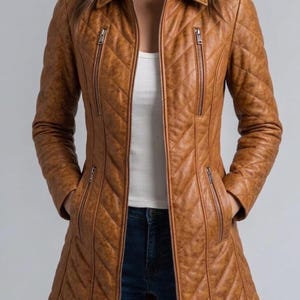 May include: A tan, quilted leather jacket with a collared neckline and a zip-up front. The jacket features two vertical zippered pockets on the chest and two on the waist. The jacket is long-sleeved and has a tailored fit.