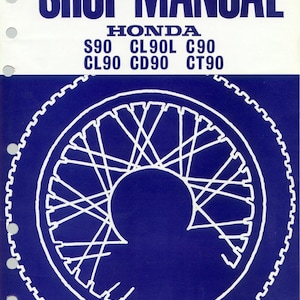 May include: A blue and white shop manual cover featuring the text "SHOP MANUAL" and "HONDA". The manual lists various Honda models: S90, CL90L, C90, CL90, CD90, and CT90. A white illustration of a motorcycle wheel is also present.