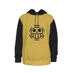 K&ouml;nnte beinhalten: Senfgelber Kapuzenpullover mit schwarzen &Auml;rmeln und Kapuze. Auf der Vorderseite befindet sich eine schwarze Grafik eines Sch&auml;dels mit einem Kreuzdesign. Der Hoodie hat eine Vordertasche und eine Kapuze mit Kordelzug.