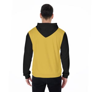 K&ouml;nnte beinhalten: Ein schwarzer und goldfarbener Kapuzenpullover mit V-Ausschnitt. Der Kapuzenpullover hat schwarze &Auml;rmel und eine schwarze Kapuze mit einer goldfarbenen Frontpartie. Die R&uuml;ckansicht des Kapuzenpullovers wird vor einem wei&szlig;en Hintergrund gezeigt.