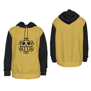 K&ouml;nnte beinhalten: Senfgelber Kapuzenpullover mit schwarzen &Auml;rmeln und Kapuze. Auf der Vorderseite befindet sich eine schwarze Grafik eines Sch&auml;dels mit Kreuz und L&auml;cheln. Der Kapuzenpullover hat eine Vordertasche und einen Kordelzug. Die R&uuml;ckseite des Kapuzenpullovers ist einfarbig senfgelb.