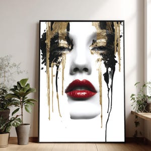 May include: A framed art print depicting a woman's face with striking makeup. The artwork uses black, gold, and red. Gold and black paint drips from the eyes, and the lips are a vibrant red. The print is suitable for home decor.