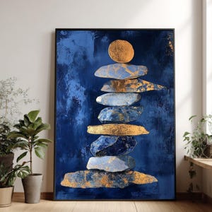 May include: Abstract art print featuring a stack of stylized stones in shades of blue and gold against a dark blue background. The artwork is framed in black and evokes a sense of balance and serenity.