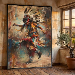 Può includere: Un'opera d'arte incorniciata raffigura un ballerino nativo americano in movimento. Il ballerino indossa un copricapo di piume e un costume colorato con accenti rossi, blu e gialli, su uno sfondo astratto strutturato con toni caldi. L'opera è esposta in una stanza con una finestra.