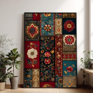 May include: A framed artwork featuring a patchwork design of floral patterns in shades of red, teal, gold, and navy. The artwork showcases various floral motifs, including large daisies and intricate, ornate designs. The frame is black, and the artwork is displayed on a wooden floor.