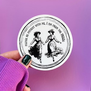 May include: A round white sticker with a black border featuring two women in vintage dresses holding hands. The text "PLEASE BE PATIENT WITH ME, I AM FROM THE 1900s" is printed around the edge of the sticker.