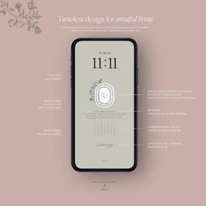 Puede incluir: Un teléfono inteligente muestra un fondo de pantalla minimalista con un fondo verde claro. La pantalla muestra la fecha y la hora, un diseño floral y texto. El teléfono es negro y está sobre un fondo rosa con detalles florales.