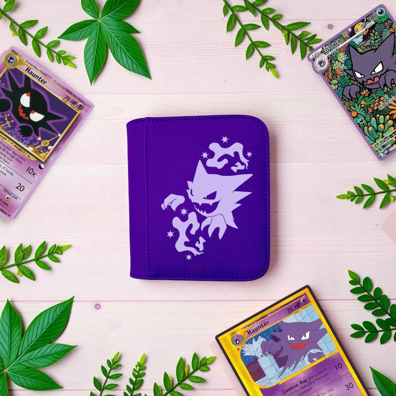 Pu&ograve; includere: Un raccoglitore per carte viola con una sagoma bianca della creatura di tipo spettro Haunter circondata da piccole forme a stella. Il raccoglitore &egrave; posizionato tra tre carte collezionabili che raffigurano la stessa creatura e rametti verdi.