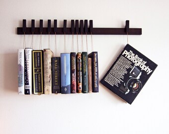 Book rack in fumed oak. Hanging bookshelf. Book hanger in dark wood. Pins work as bookmarks. Bookcasw. Floating bookshelf. Unique library.