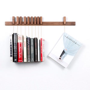 Custom made wooden book rack / bookshelf in Walnut. Pins also work as bookmarks. Bookcase
