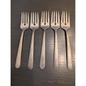 May include: A set of three ceramic nesting bowls in graduating sizes. The bowls feature a speckled, matte finish in shades of cream, light brown, and dark brown. The largest bowl is approximately 8 inches in diameter.