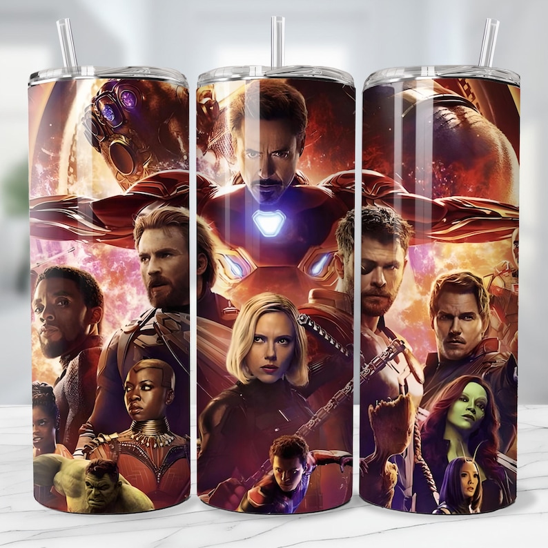 May include: A stainless steel tumbler featuring a vibrant collage of characters from the Avengers movie series. The design includes Iron Man, Captain America, Black Widow, Thor, and others, set against a fiery, space-themed background. The tumbler has a clear straw.