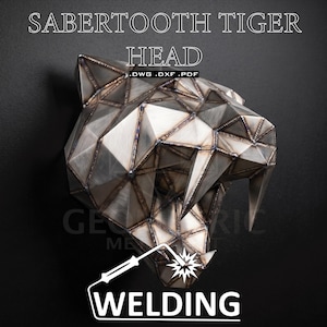 May include: A metallic, geometric sculpture of a sabertooth tiger head constructed from welded steel plates. The surface features visible weld seams at the joints. Text on the image reads SABERTOOTH TIGER HEAD .DWG .DXF .PDF and WELDING.