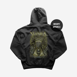 Op de afbeelding: Donkergrijze hoodie met een grafisch ontwerp op de rug. Het ontwerp toont de bandnaam "Veil of Maya" boven een zandloper- en schedelillustratie. De merknaam "Moshpit Apparels" is gedrukt op een zwarte cirkel.