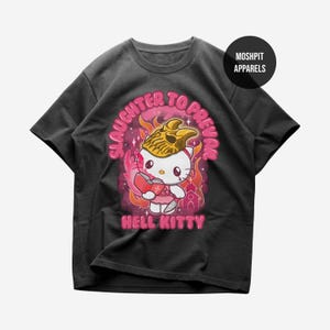 May include: Black t-shirt featuring a cartoon illustration of Hello Kitty as a devil, with the text "Slaughter to Prevail" and "Hell Kitty" in pink. The design includes flames and a small building.