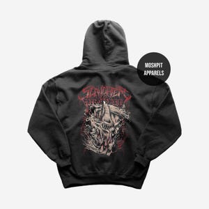 May include: Dark gray hoodie with a graphic design on the back. The design features a skull with red and white accents, and the text "SLAVERY TO CONSUMPTION" in red. A black circle with the text "MOSHPIT APPARELS" is on the upper right.