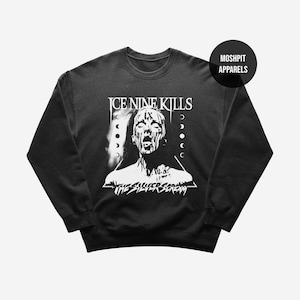 May include: Black sweatshirt with a white graphic of a screaming person, the text "ICE NINE KILLS" above and "THE SILVER SCREAM" below. The design includes a triangle and moon phases. A circular logo with "MOSHPIT APPARELS" is in the upper right.