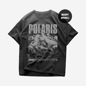 Puede incluir: Camiseta gris oscuro con un gráfico de una cordillera y la palabra "POLARIS" en negrita, con un efecto desgastado. Debajo del gráfico de la montaña está la palabra "SUMMIT". La camiseta tiene cuello redondo y mangas cortas.