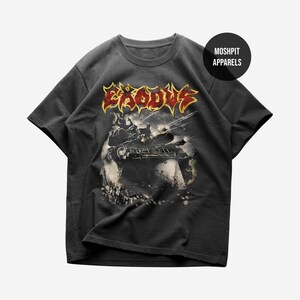 Peut inclure: T-shirt gris foncé avec le nom du groupe "Exodus" en or et rouge. Le graphisme représente un char dans une scène de guerre. Le t-shirt a un col rond et des manches courtes. Un logo rond en haut à droite indique "Moshpit Apparels".