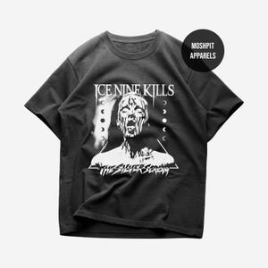 May include: Black t-shirt with a white graphic of a screaming face with dripping details, the band name "ICE NINE KILLS" above, and "THE SILVER SCREAM" below. A round logo with "MOSHPIT APPARELS" is on the upper right.
