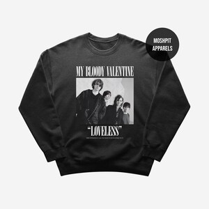May include: Black crew neck sweatshirt with a black and white image of the band My Bloody Valentine. The word "LOVELESS" is printed below the image, with the band's name above. The sweatshirt has the "Moshpit Apparels" logo.