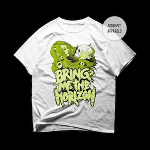 Puede incluir: Camiseta blanca con un diseño gráfico verde. El diseño incluye la cara de una mujer, una calavera y las palabras "BRING ME THE HORIZON" en una fuente estilizada. La camiseta tiene mangas cortas y cuello redondo.