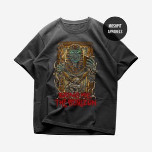 May include: Dark gray t-shirt featuring a detailed graphic of a pharaoh with glowing green eyes and the text "BRING ME THE HORIZON" in red. The design includes a skull and hieroglyphic elements, with the brand logo "MOSHPIT APPARELS" in a circle.