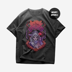 Puede incluir: Camiseta gris oscuro con una ilustración de fantasía de un personaje sosteniendo una muñeca, una bola roja y un hada. El diseño está enmarcado por un borde rojo y morado. El texto "MOSHPIT APPARELS" está en un logotipo circular.