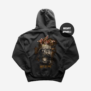 May include: Dark grey hooded sweatshirt with a graphic of a skull-like face and the word "Nile" above it. The design is in brown and gold. The sweatshirt has a hood and the text "Moshpit Apparels" on the upper right.