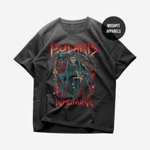 Puede incluir: Camiseta gris oscuro con un diseño de la muerte. Las palabras "POLARIS" e "INHUMANE" son rojas. La muerte lleva una capa negra, empuñando una guadaña, con llamas y relámpagos.