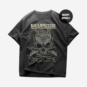 May include: Dark gray t-shirt featuring a skull graphic with the text "KILLSWITCH ENGAGE" above and "NO END IN SIGHT" below. The graphic is in shades of gray and tan. The shirt has short sleeves and a crew neck. The brand name "MOSHPIT APPARELS" is in a circle.