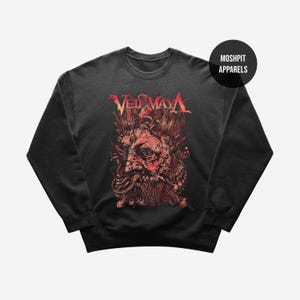 Op de afbeelding: Donkergrijze sweatshirt met een rood en oranje afbeelding van een bebaard gezicht en de tekst "VEIL OF MAYA". De sweatshirt heeft een ronde hals en lange mouwen. De merknaam "MOSHPIT APPARELS" is op een zwarte cirkel gedrukt.