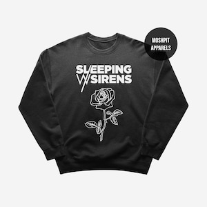 May include: Black crew neck sweatshirt featuring the text "SLEEPING WITH SIRENS" in white, with a white rose illustration below. The brand name "MOSHPIT APPARELS" is printed on a black circle in the upper right corner.