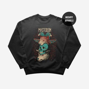 May include: Dark gray sweatshirt featuring a stacked graphic of a tiger, skull, and wolf with wings. The word "MASTODON" is printed above the graphic in a distressed font. The sweatshirt has a crew neck and long sleeves.
