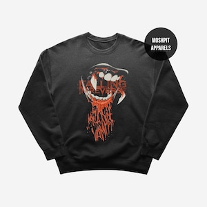 May include: Dark grey sweatshirt with a graphic of a vampire mouth, fangs, and dripping blood. The text "FALLING IN REVERSE" is printed in red across the mouth. A black circle with "MOSHPIT APPARELS" is in the upper right.
