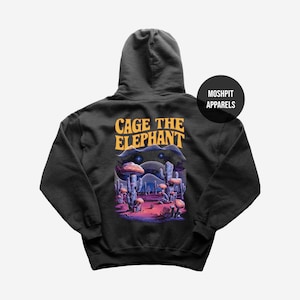 May include: Black hoodie featuring a desert landscape design with mushrooms and cacti. The text "CAGE THE ELEPHANT" is printed in orange above the graphic. A black circle with "MOSHPIT APPARELS" is on the right.