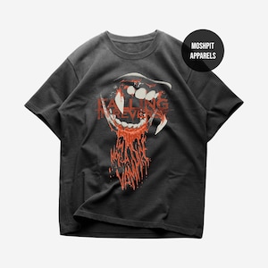 May include: Dark grey t-shirt with a graphic of a snarling mouth with dripping red blood and the words "FALLING IN REVERIE". The shirt also has a black circle with the words "MOSHPIT APPARELS".
