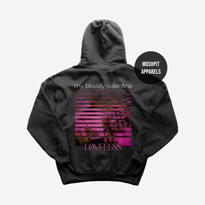 May include: Dark grey hoodie featuring the text "my bloody valentine" above a pink and red striped design. The word "LOVELESS" is printed below the design. A black circle with the text "MOSHPIT APPARELS" is on the upper right.