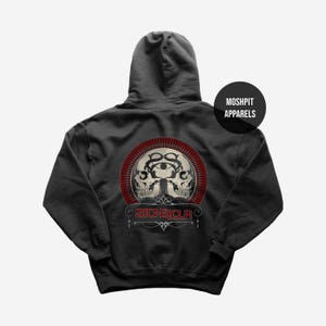 May include: Dark gray hoodie featuring a circular graphic with two skulls, an eye, and the text "STONESOUR" in red and white. The hoodie has a hood and a front pocket. The brand name "MOSHPIT APPARELS" is printed on a black circle.