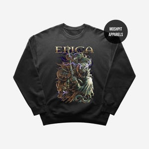 May include: Black sweatshirt with a graphic design featuring the word "ERICA" in gold lettering above a detailed illustration of a skeletal figure holding a staff, with a wolf and serpent. The brand name "MOSHPIT APPARELS" is in a black circle.
