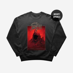 Może przedstawiać: Ciemnoszara bluza z czerwoną grafiką. Grafika przedstawia słowo "DEATH" w stylizowanej czcionce i ilustrację krzyczącej postaci. Tekst "THE SOUND OF PERSEVERANCE" znajduje się pod grafiką. Nazwa marki "MOSHPIT APPARELS" znajduje się w prawym górnym rogu.