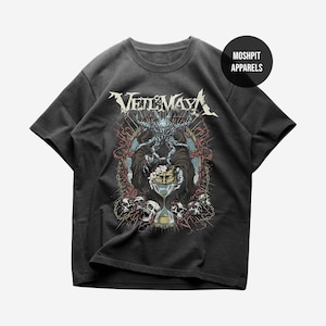 Op de afbeelding: Donkergrijs t-shirt met een gedetailleerd grafisch ontwerp. Het ontwerp bevat de tekst "Veil of Maya" in een gestileerd lettertype, samen met een illustratie van een demonische figuur, schedels en een zandloper. Het shirt heeft ook de tekst "Moshpit Apparels".