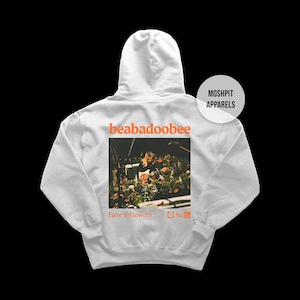 May include: A pale grey hooded sweatshirt with a graphic on the back. The graphic includes the word "beabadoobee" above a photo of a person on stage with flowers. The words "Fake It Flowers" are below the photo.