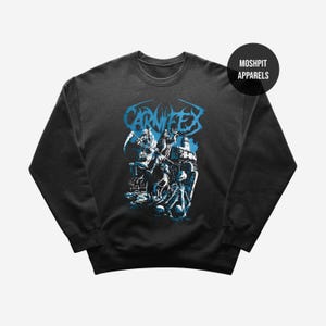 May include: Black crew neck sweatshirt with a blue graphic. The graphic features the band name "CARNIFEX" and an illustration of a grim reaper and skeletal figures. The sweatshirt has a round neckline and long sleeves. The brand name "MOSHPIT APPARELS" is in a black circle.