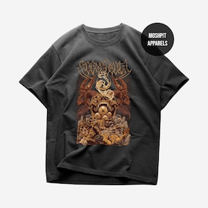 May include: Dark gray t-shirt featuring a detailed graphic design with a skull, dragons, and other figures in shades of brown and gold. The text "SEPULTURA" is at the top. The brand name "MOSHPIT APPARELS" is in a black circle.