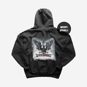 May include: Dark gray hoodie featuring a distressed graphic of a black eagle with outstretched wings. The text "ALTER BRIDGE blackbird" is below the eagle. The hoodie has a hood and a front pocket. The brand name "MOSHPIT APPARELS" is on the upper right.