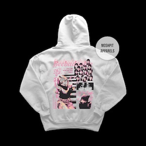 May include: A pale grey hoodie with a graphic design on the back. The design includes a collage of images, a woman, the text "Beebebad", and the words "Tell Me How Do You Feel". The hoodie has a hood and a front pocket.