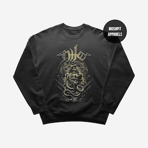 May include: Dark grey sweatshirt with a detailed graphic of a skull and snakes, with the word "Nile" in a stylized font. The design includes a circular background and is set against a dark background. The brand name "Moshpit Apparels" is in a black circle.