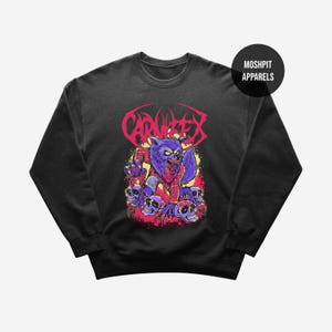 Puede incluir: Sudadera negra con un gráfico de hombre lobo morado, detalles de cuadros rojos y calaveras. La palabra "CARNIFEX" está en rosa. El diseño tiene un tema de terror.